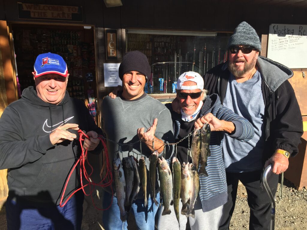 A photo of three men smiling with a stringer of fish