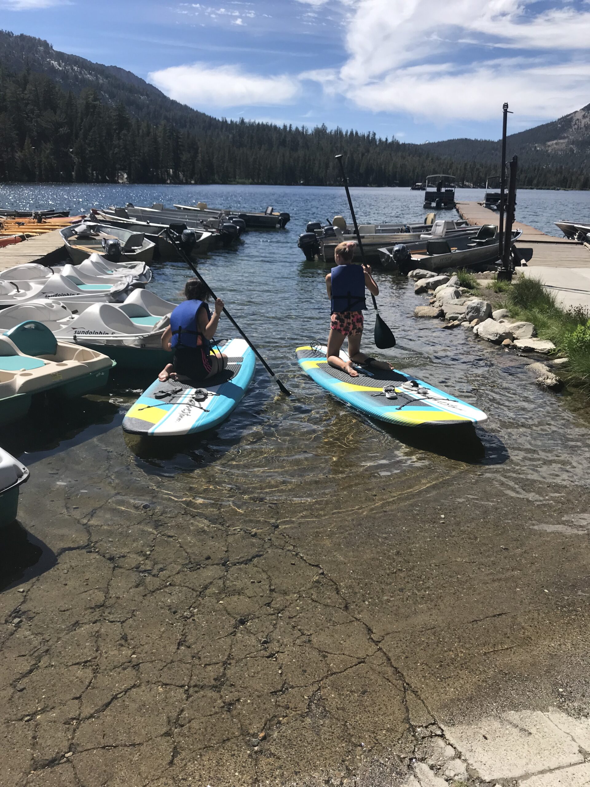 Photo of two people on paddle boards about to paddle on to the lake